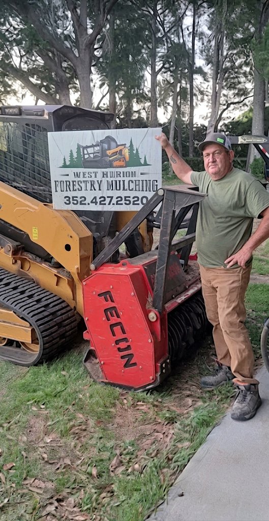 Craig Wright of West Marion Forestry Mulching standing beside his skid steer and Fecon mulching head in Dunnellon, FL